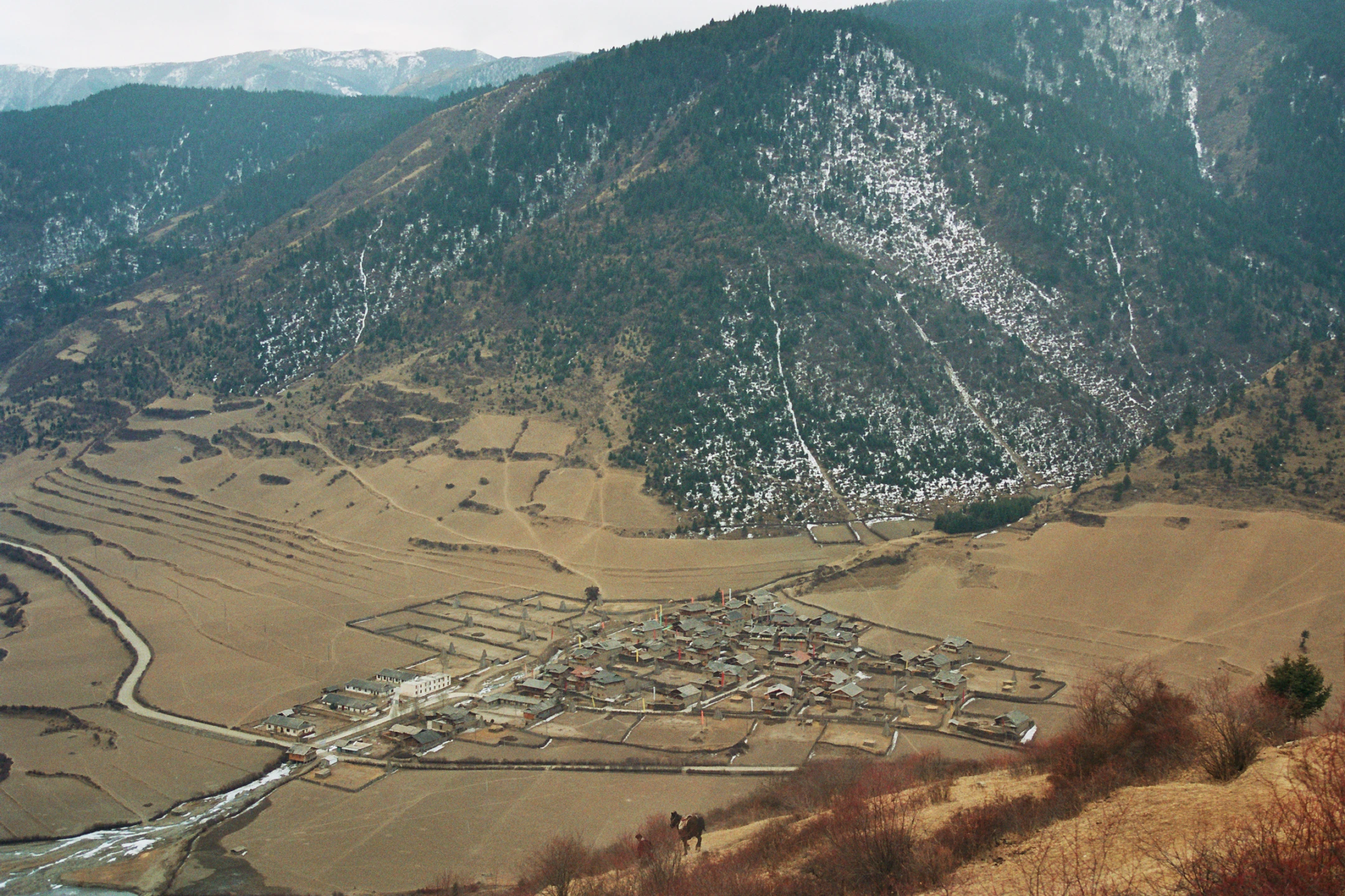 Photo : Village traversé par une rivière dans une vallée du Parc Naturel National de Jiuzhaigou, Sichuan, Chine.
