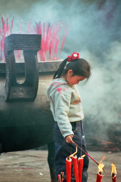 Photo : Enfant allumant une bougie au Temple Wenshu de Chengdu, Sichuan, Chine.