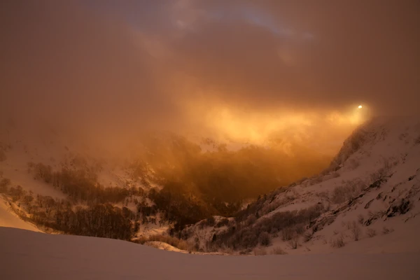 Photo : Cirque du Hohneck enneigé, dans un levé de brume orangée en hiver, Vosges.